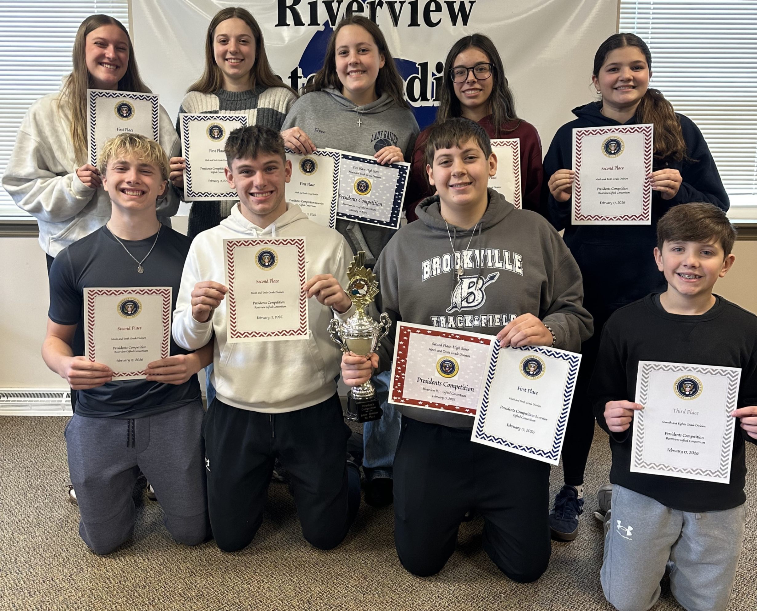 Students that participated in the presidents competition at RIU 6 pose for a group photo while holding their certificates.